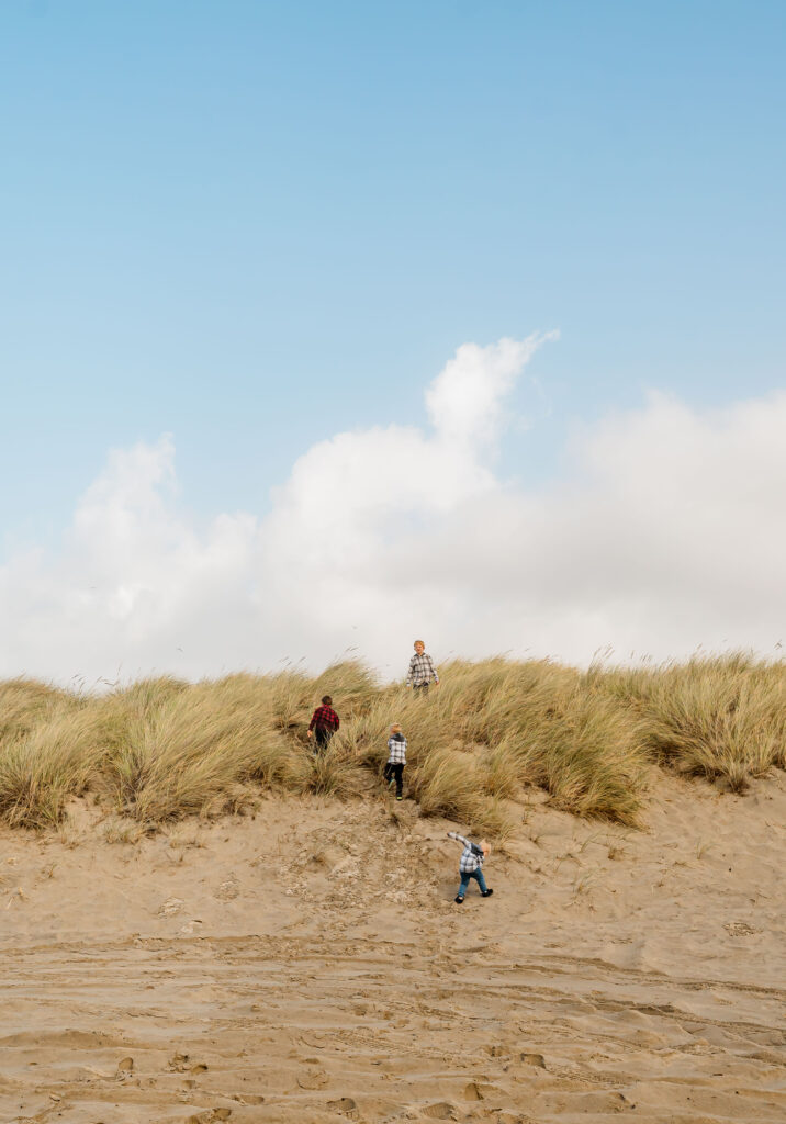 Kids playing in sea grass on the beach in Lincoln City, Oregon 