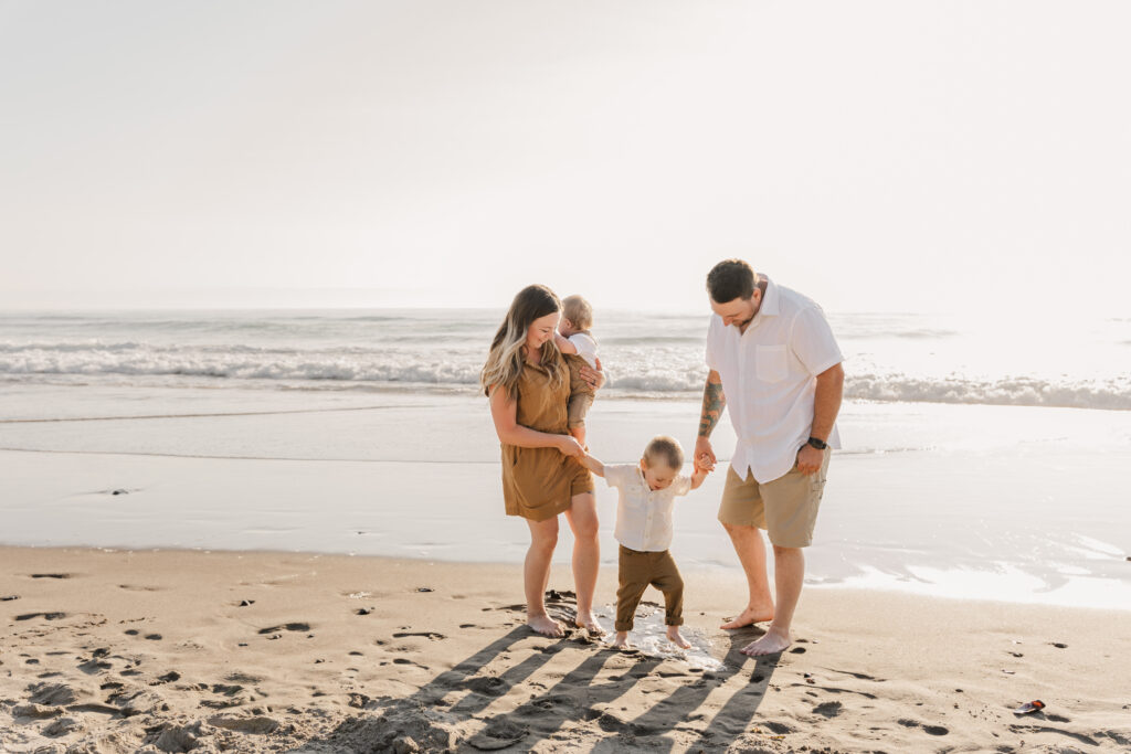Family walking along the shoreline at Roads End Beach in Lincoln City Oregon.