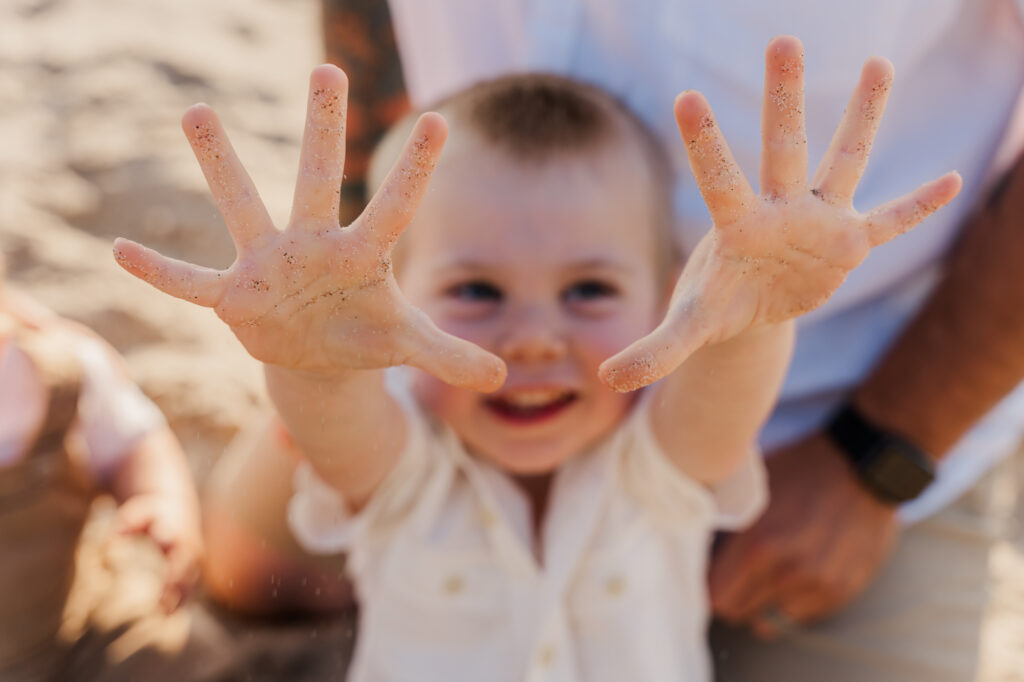 Joyful candid moment of a family laughing together at Roads End Beach.