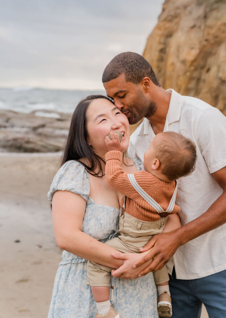 Husband and wife with child on the beach in Pacific City, Oregon