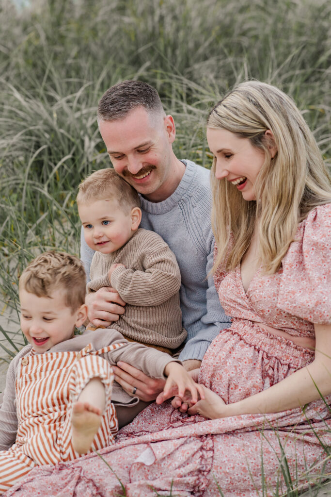 Moody Oregon Coast fall family photography session - candid family laughing on the beach